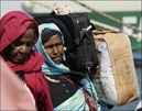 Sudanese Muslim pilgrims carry their luggage as they disembark from a ship at Jeddah's port...