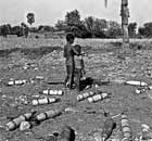 Two young boys are surrounded by spent rocket bombs in Jessore, Bangladesh, in 1971