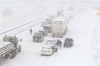 Tow trucks assist the Colorado State Patrol to clear stalled...