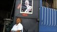 A woman sits outside a shop with a picture of Venezuelan President Hugo Chavez on the door in Caracas on 17 September 2010