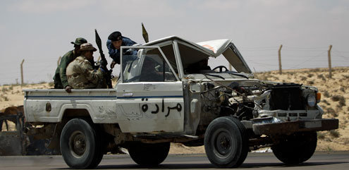 Rebel fighters retreat out of Ajdabiya during an advance by pro-Gadhafi forces, on the outskirts of Ajdabiya, Libya Saturday, April 9, 2011. Government soldiers and rebel gunmen battled in the streets of the key front-line city of Ajdabiya Saturday after