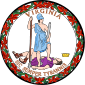 A circular seal with the words "Virginia" on the top and "Sic Semper Tyrannis" on the bottom. In the center, a woman wearing a blue toga and Athenian helmet stands on the chest of dead man wearing a purple breastplate and skirt. The woman holds a spear and sheathed sword. The man holds a broken chain while his crown lies away from the figures. Orange leaves encircle the seal.