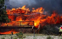 A firefighter works the scene of a home being consumed by flames in Estes Park, Colorado