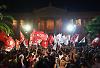 Supporters of SYRIZA wave flags outside a university building on election night.