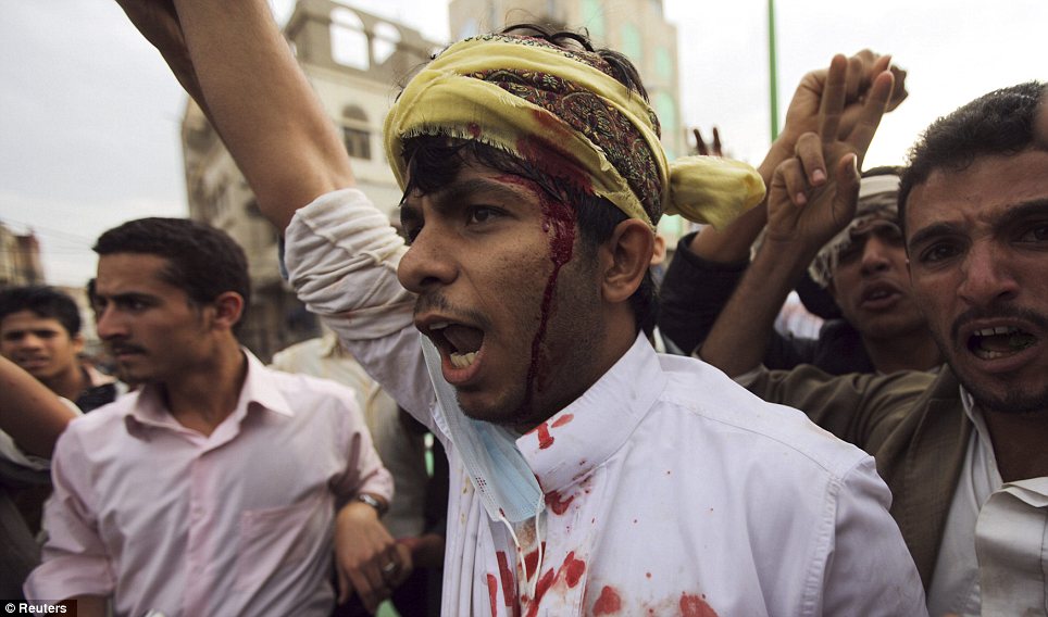 Bloody: A blood-soaked protester shouts slogans after sustaining injuries from a confrontation with riot police who fired tear gas at them outside the embassy