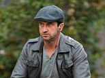Taking 'going green' quite literally! Gerard Butler swaps his motorbike for a bicycle and dresses in head-to-toe khaki