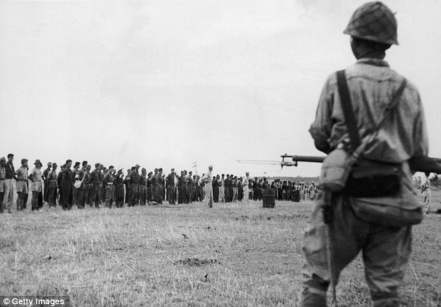 At Bayonet point: Japanese troops guard American and Filipino prisoners in Bataan in the Philippines after their capture on 9th April 1942. 