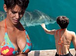 Getting close to nature: Halle Berry reaches out to touch a great white shark in behind-the-scenes footage for her film Dark Tide 