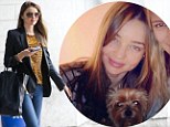 Weathering the storm with a smile: Miranda Kerr arrives at JFK then waits out Sandy with her pup 