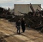 Wild west: People walk through the heavily damaged Rockaway neighborhood in Queens where a large section of the iconic boardwalk was washed away