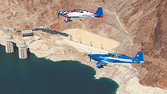 Two aerobatic planes flying over the Hoover Dam