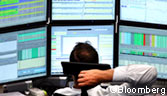 A financial trader monitors his computer screens inside the Frankfurt Stock Exchange