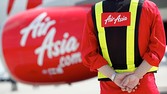 An AirAsia Japan Co. engineer stands near the company's first Airbus SAS A320 aircraft during a media preview at Narita Airport in Narita City, Chiba Prefecture, Japan, on Monday, June 11, 2012. AirAsia Japan will start flights between Tokyo and Sapporo, Fukuoka, and Okinawa from August, it announced on May 30.