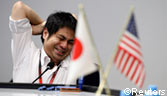 A foreign exchange broker stretches at a dealing room in Tokyo