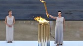 Actress Ino Menegaki at the role of the high priestess holds the torch with the flame during the handover ceremony