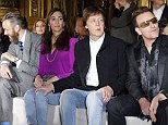 Taking it all in: Sir Paul placed a protective hand on his wife's knee as they took in the show 