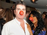 Not seeing the funny side: Simon Cowell failed to crack a smile as he sported a red nose at the gala performance of Book of Mormon in London on Wednesday night