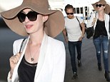 Classic beauty: Anne Hathaway was the picture of 1950s glamour as she headed to departing flight with husband Adam Schulman