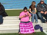 Fed up: A woman attending Wrestlemania 29 in New Jersey last Sunday brought with her a bright pink sign calling out the exact seat and row of out her cheating husband