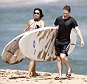 Weary: The couple were photographed trudging wearily up the beach after a hard afternoon of sun, sea and surf, both grimacing under the weight of their massive boards
