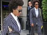 Solange Knowles' fashion adventure takes a wrong turn as she wears a bizarre pinstripe suit that's slashed open to reveal her bra