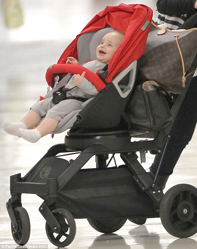 Happy as a clam: The eight-month-old looked cheery after their long flight