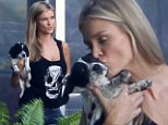 'And they called it puppy love!' Model Joanna Krupa smothers her dog with kisses as she carries her close to her heart