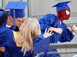 That's one way to knock her hat off! Andrew Garfield surprises girlfriend Emma Stone with a big smooch as the pair graduate from high school on the set of Spider-Man 2