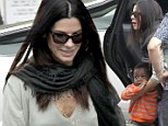 Sandra Bullock takes her son Louis Bardo to school this morning and looked great in an olive V-neck sweater