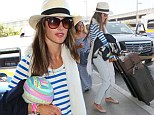 She's got wings! Angel Alessandra Ambrosio shows spirit in striped top and Panama hat as she hauls her luggage to LAX