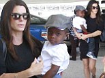 Her precious cargo! Sandra Bullock displays her chic travel style as she carries son Louis through LAX