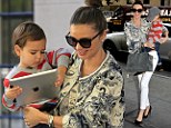 Digital dude: Miranda Kerr's son holds onto his iPad as she holds onto him... in four inch heels no less