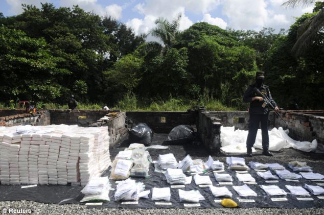 A tidy sum: Packets of cocaine are closely guarded by officials from the country's police force