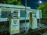 Abandoned gas station on the edge of Mineral Wells, Texas: It is dark with a 1/2 moon, ambient light of all kinds from several directions, CTO-gelled NEBO Redline flashlight and Noel uses a Mercury-vapor lamp behind the building to light up the trees
