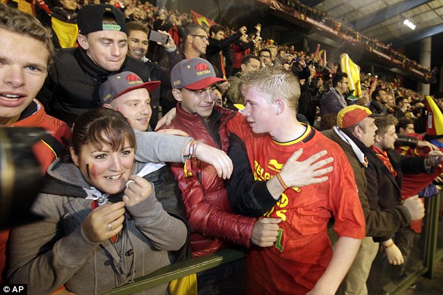 One of the lads: De Bruyne celebrates after the game with jubilant Belgian supporters