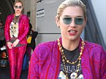 There's no missing her at the baggage claim! Kesha stands out at the airport in a hot pink and purple paisley suit