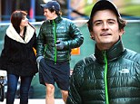 Orlando Bloom beams as he strolls arm-in-arm with a mystery woman in New York