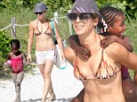 Hold on tight! Jillian Michaels piggybacks daughter Lukensia at the beach as she shows off her Biggest Loser body in a bikini top and tiny shorts 