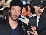 Dressed for success! Keanu Reeves looks dapper as he signs autographs in Japan