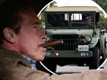 Arnold Schwarzenegger smokes a cigar as he drives a vintage Jeep