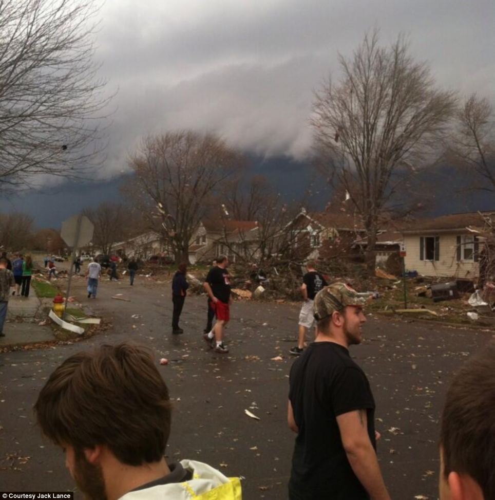 Twister: Neighbors in Pekin, Illinois - just south of Peoria - survey the damage to their street shortly after a tornado touched down in the area