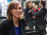 Some help you are! Karlie Kloss meets male friend in New York... but he leaves her to lug her own luggage