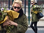 Michelle Williams wrangles the elements and an enormous bouquet of flowers on her windy morning walk