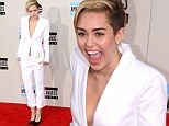 How demure Miley! Cyrus is low key as she arrives in grown-up white suit for the AMAs... but still doesn't wear a bra