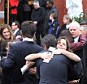 Widowed: Nancy Montgomery, center, hugs friends and family following her husband's funeral service