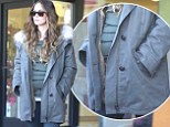 Pregnant Megan Fox's small baby bump pokes out of her hooded winter coat while buying beauty products
