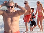 Still a tough guy at 74! Harvey Keitel flexes his muscle while frolicking on Rio de Janeiro beach with his family