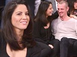 What basketball game? Olivia Munn and Joel Kinnaman are oblivious to the action as they cuddle up courtside