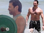 Getting pumped for the beach! Hugh Jackman swings heavy weights at the gym... then goes for shirtless swim in Australia