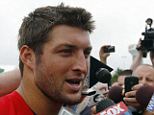Behind the mike: Former NFL quarterback Tim Tebow talks to reporters during his short spell at the New England Patriots. He is now taking a job as a TV analyst with ESPN